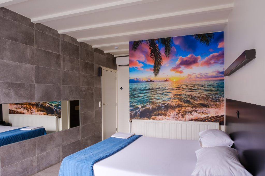 Tropical-kamer bij Carotel Rumst met fotobehang van een zonsondergang aan zee