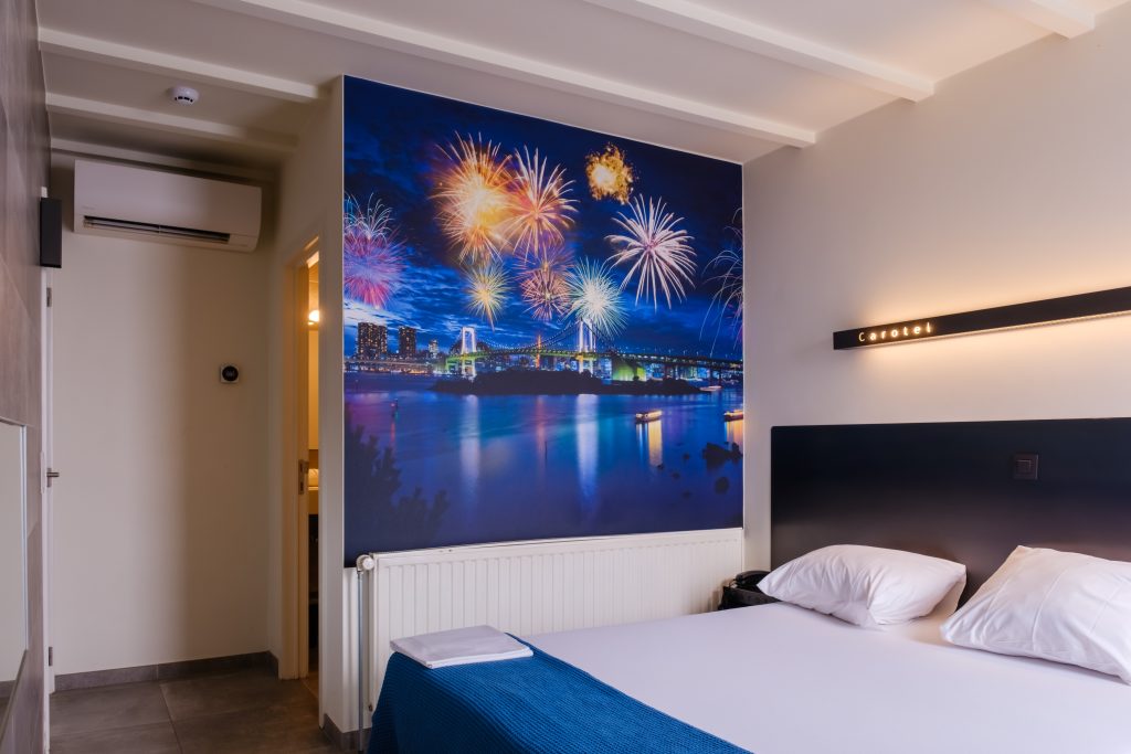 Kamer bij Carotel Rumst met tweepersoonsbed en fotobehang van vuurwerk