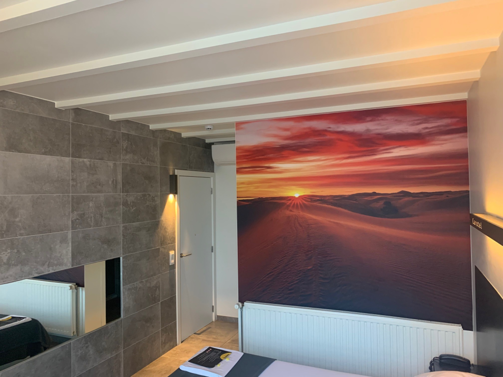 Rustige kamer bij Carotel met fotobehang van een zonsondergang
