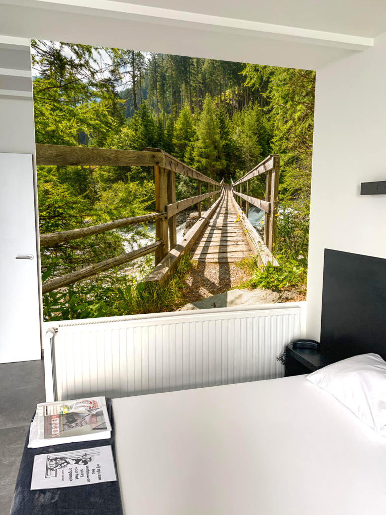 Kamer met fotobehang van een houten hangbrug in het bos